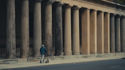 穿蓝夹克黑裤子的人白天在路上骑自行车